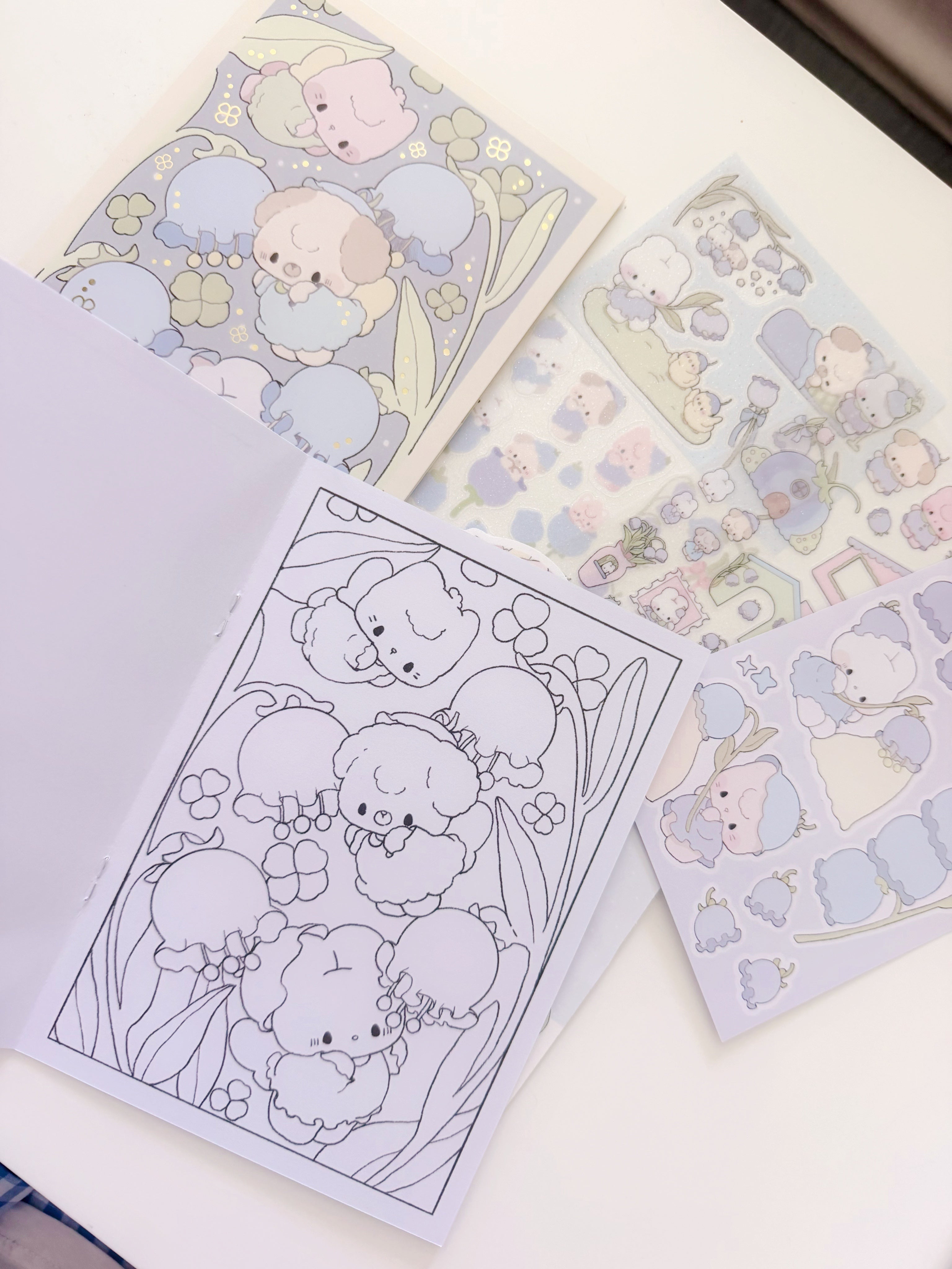 Set of cute animal-themed stickers and coloring pages on a white surface
