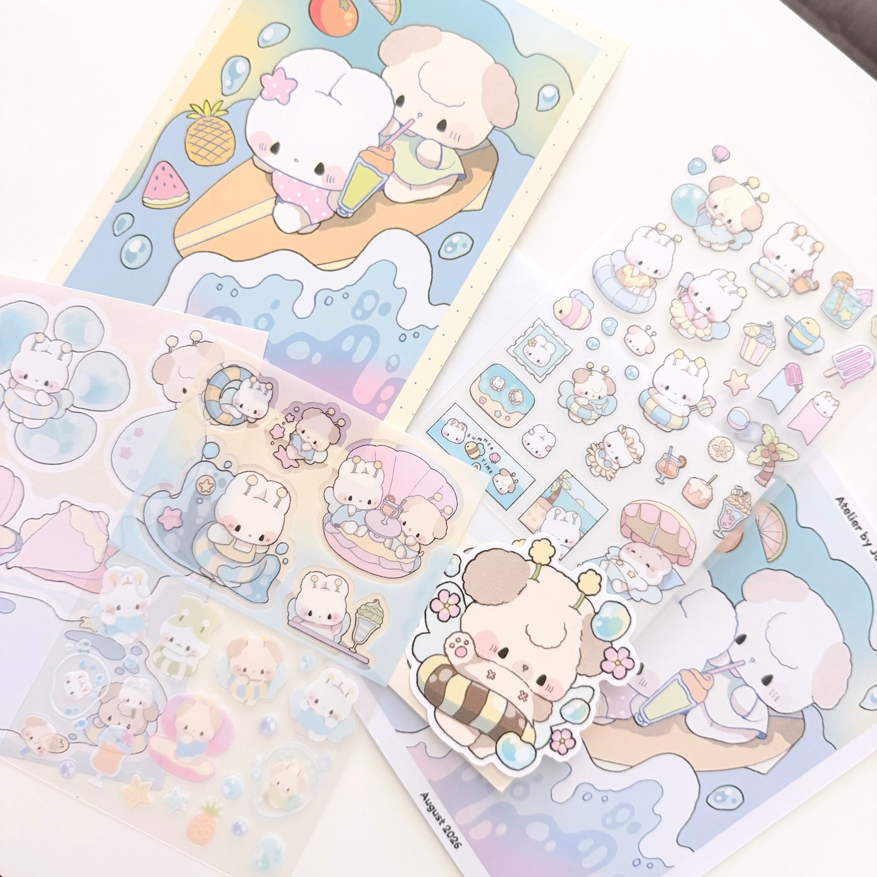 A collection of cute pastel sticker sheets featuring cartoon animal characters in a beach-themed illustration, arranged on a white surface.